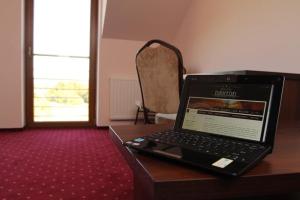 a laptop computer sitting on top of a wooden table at Gościniec Europejski in Miedziana Góra +22 photos