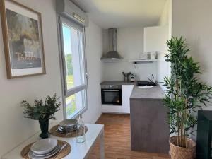 cocina con mesa blanca y encimera en ღ Jumanji - Proche Parc et Commodités & Wifi, en Sainte-Luce-sur-Loire 7 fotos más