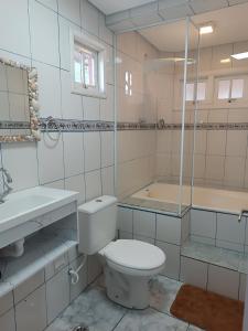ein Badezimmer mit Toilette und Badewanne in der Unterkunft Maresias chalé in Maresias