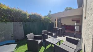 eine Terrasse mit Stühlen und Tischen im Hinterhof in der Unterkunft "Villa de Jade" Maison de vacances en residence avec piscine - Clim - parking in Saint-Cyprien