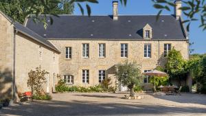un grand bâtiment en briques avec un toit dans l'établissement La Cour Souveraine - Chambre d'hôtes Le Cap, à Mosles