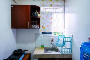 a small kitchen with a sink and a window at Nayas Haven Studio2 in Mombasa Bamburi Mtambo Mwembeni with hot shower in Mombasa
