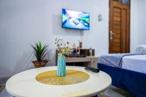 a table with a vase with flowers on it at Nayas Haven Studio2 in Mombasa Bamburi Mtambo Mwembeni with hot shower in Mombasa +2 photos