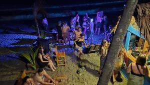a group of people on the beach at a party at Bob Marley Beach in Guachaca