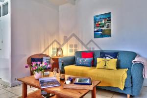 a living room with a couch and a table at LocaLise - M26B - Les Belles Âmes - Maison rénovée avec jardin entièrement clos - place de parking sur le terrain - wifi inclus - draps inclus - animaux bienvenus in Le Guilvinec