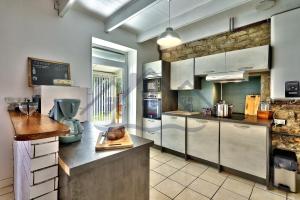 a kitchen with stainless steel cabinets and a counter top at LocaLise - M26B - Les Belles Âmes - Maison rénovée avec jardin entièrement clos - place de parking sur le terrain - wifi inclus - draps inclus - animaux bienvenus in Le Guilvinec