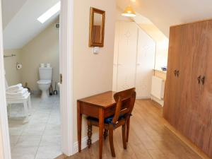 Kilcash Castle Cottage في Kilcash: غرفة بها مكتب خشبي ومرحاض +28 صورة