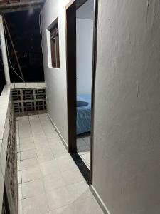 a door to a balcony with a view of the ocean at Um quarto completo in João Pessoa