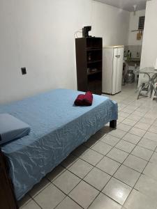 a bedroom with a bed with a blue comforter at Um quarto completo in João Pessoa