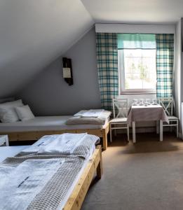 Un dormitorio con dos camas y una mesa y una ventana. en Słotwiny Arena, en Krynica-Zdrój