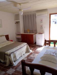 una camera da letto con due letti e un tavolo di Maison Aires Malcher a Maricá