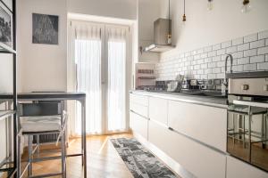 a kitchen with white cabinets and a counter top at Elegante Bilocale in Zona Tortona in Milan +7 photos