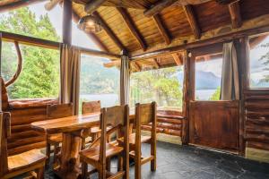 a dining room with a table and chairs and large windows at Cabañas Villa Labrador con costa de lago in San Carlos de Bariloche +57 photos
