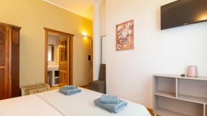 a room with a bed with blue towels on it at Bosa Eye House 1873 in Bosa