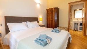 a bedroom with a large white bed with towels on it at Bosa Eye House 1873 in Bosa