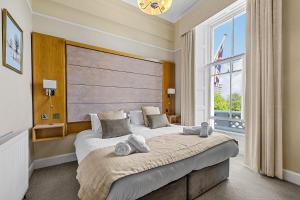 Un dormitorio con una cama grande con una ventana grande. en Invicta Hotel Plymouth, en Plymouth