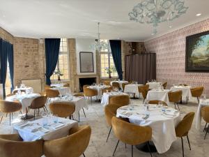 a dining room with white tables and chairs at Hôtel Le Château Fort de Sedan in Sedan
