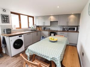une cuisine avec une table avec un bol de fruits dessus dans l'établissement Lavender Cottage, à Okehampton