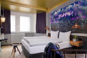 1 dormitorio con 1 cama y una pintura en la pared en Staytion Urban City Hotel Mannheim, en Mannheim