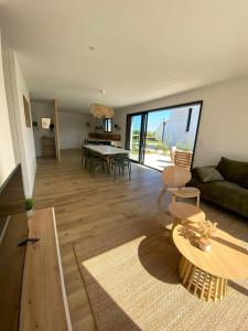 ein Wohnzimmer mit Sofa und Tisch in der Unterkunft Villa Palulova - maison 8 personnes - SPA in Plouescat