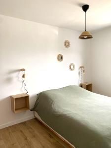 ein Schlafzimmer mit einem Bett und einer Uhr an der Wand in der Unterkunft Villa Palulova - maison 8 personnes - SPA in Plouescat + 24 Fotos