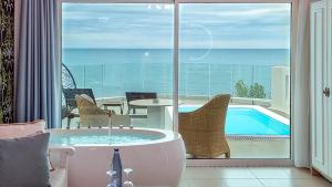 wanna w pokoju z widokiem na ocean w obiekcie Panorama Suites & Spa - Adults Only w mieście Stomio