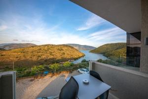 a view of a river from a balcony with a table and chairs at Inada Rooms Ksamil in Ksamil