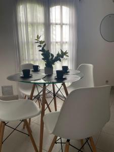 a table with white chairs and a potted plant on it at Departamento centrico in Paraná