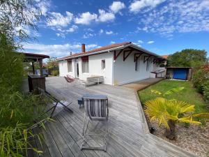 un patio trasero con una terraza de madera y una casa en La Casita, en Arès