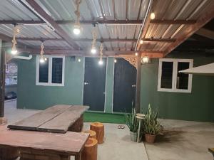a patio with a wooden table and some plants at De sepakat cottage private pool in Kuantan