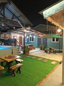 a patio with picnic tables and a pool table at De sepakat cottage private pool in Kuantan