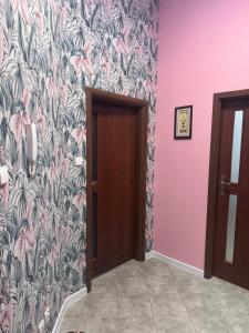a hallway with a wall with a floral wallpaper at Kamienica Apartament Iława PIERWSZE PIĘTRO in Iława