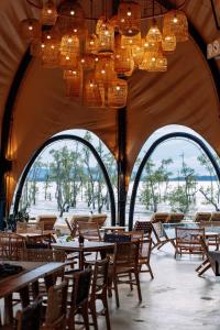 クチンにあるCocoon Resort Kuchingのテーブル、椅子、シャンデリアが備わる広い客室です。