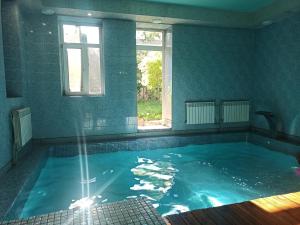 a large swimming pool with a window and blue walls at Номер у моря, бассейн, сад, мангал in Odesa
