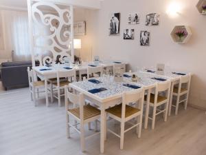 Pietra Pomice Hotel في كانّيتو: غرفة طعام بيضاء مع طاولات وكراسي بيضاء