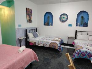 a room with two beds and two tables and mirrors at Ganesha HOSTAL in Mexico City