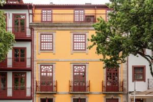 a yellow building with windows and balconies at Plaza Apartments by HostWise in Guimarães