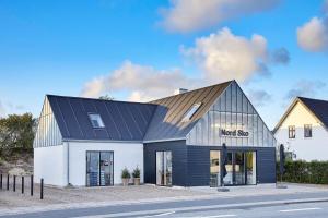 a modern house with a metal roof at Cozy big apartment in Blokhus