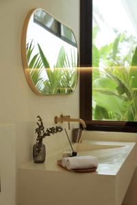 a bathroom sink with a mirror and a towel at Balear Villa in Kuta Lombok +21 photos