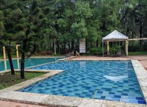 a swimming pool with a blue tile floor and a gazebo at Mi Casa Nova in Bacolod