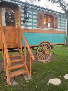 a blue and brown house with a wooden wagon at Roulotte de charme in Villers-sur-Authie +8 photos