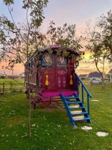 a small playground with a slide in a field at Roulotte, pleine de charme in Villers-sur-Authie