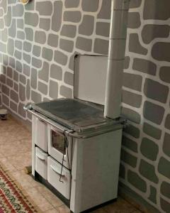 a stove top oven sitting next to a wall at RiverLand House in Librazhd