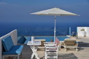 a pool with chairs and a table and an umbrella at 65 Stairs Τo Ηeaven Private Pool in Áno Meriá