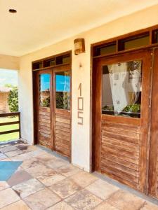 a pair of wooden doors on a house at Ondas do mar Taiba Residence in Taíba