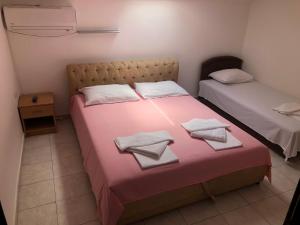 a bedroom with two beds with towels on them at Apartmani Centar in Petrovac na Moru