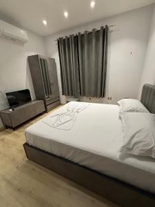 una camera con un grande letto e una televisione di Cozy Collective - Heart of Tirana a Tirana