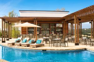 a pool with chairs and tables in it at La Cantera Resort & Spa in San Antonio