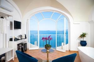 a living room with a large window with a view of the ocean at Villa Santa Chiara Positano Suites in Positano