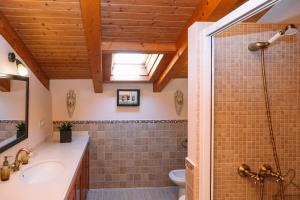 un bagno con doccia e lavandino di O Lar do Bispo by CABANA Rentals a Arbo Altre 25 foto